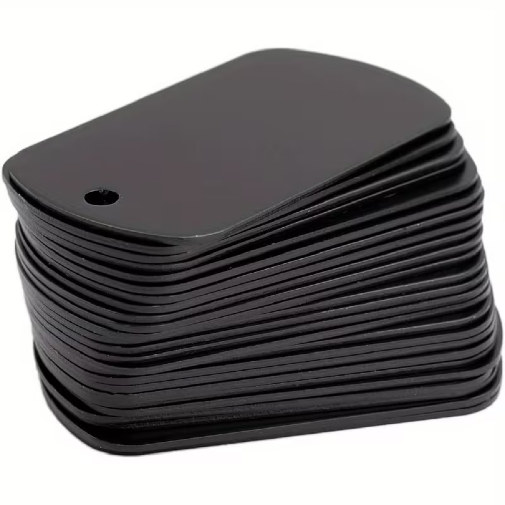 Placeholder photograph of stacked black metal dog tags with attachment holes.